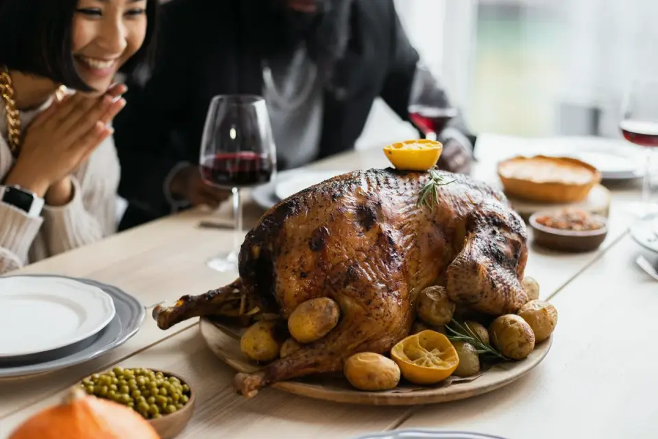 A dog looking up at a Thanksgiving table set with turkey and side dishes