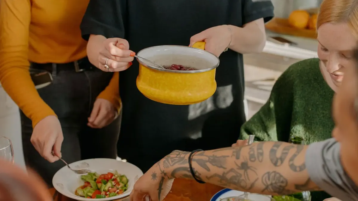 A dog pausing over its food bowl in a kitchen