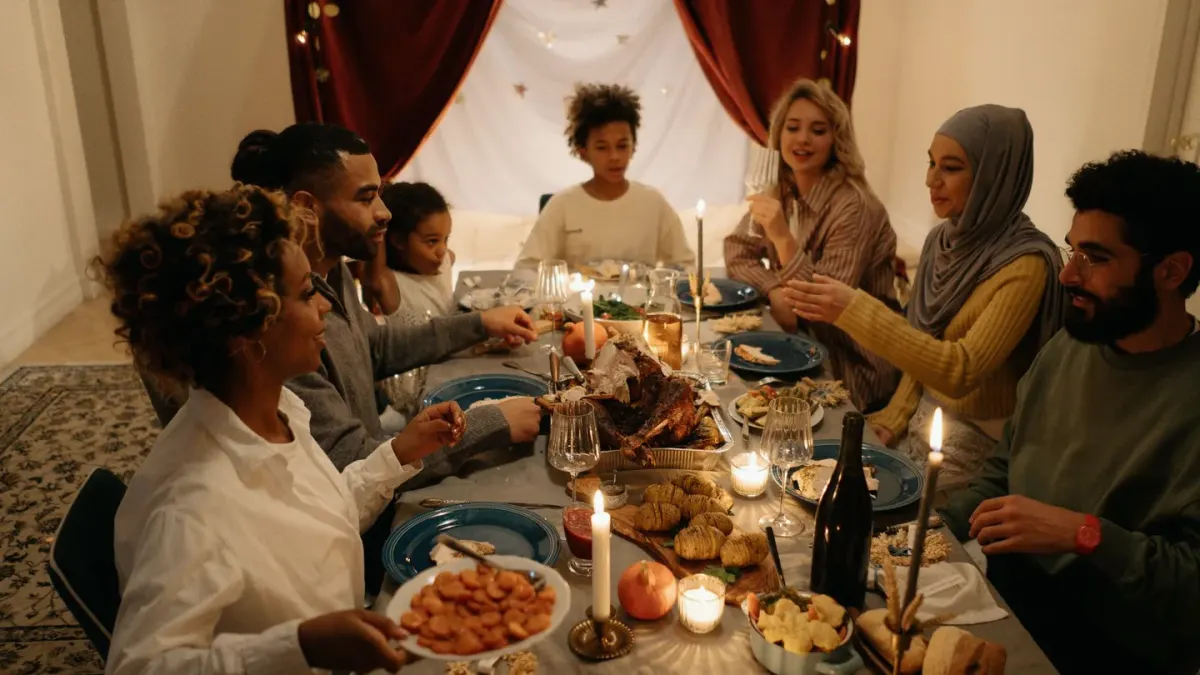 A golden retriever sitting attentively near a table set for Thanksgiving dinner