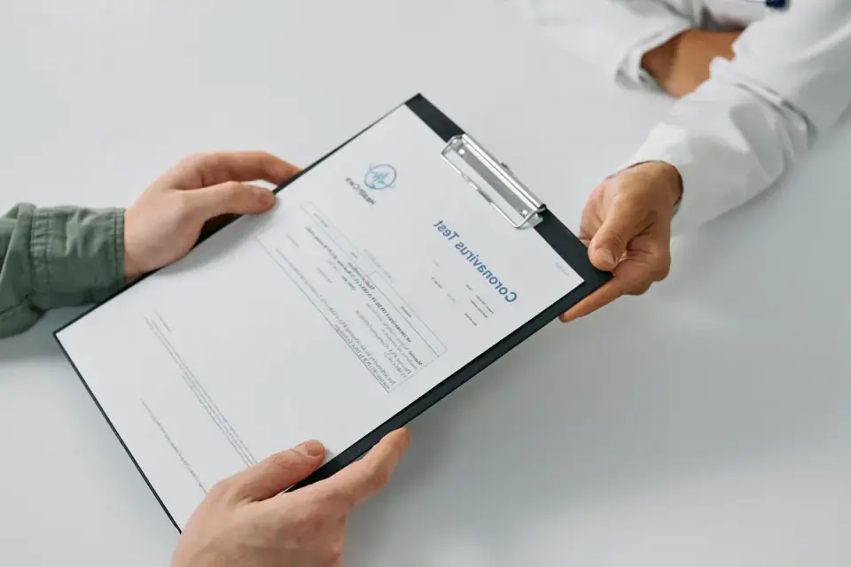 A veterinarian reviewing a printed bloodwork panel with a dog owner